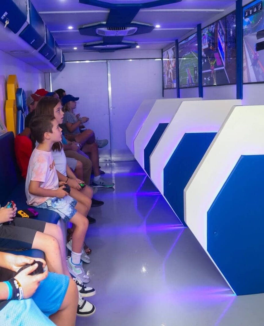 Kids playing video games inside mobile gaming trailer