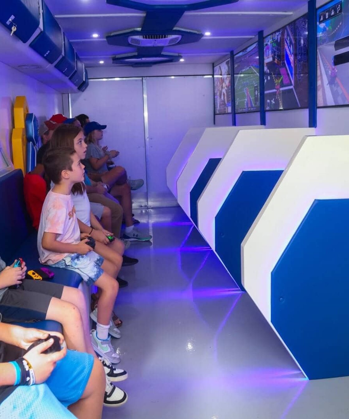 Kids playing video games inside mobile gaming trailer