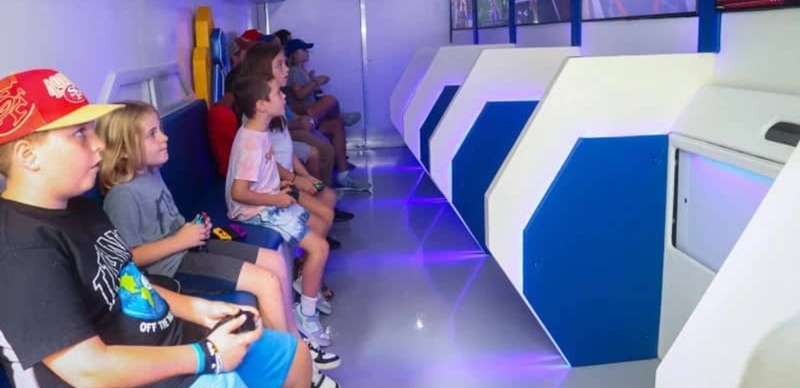 Interior of the AFK Mobile Arcade gaming trailer with lit screens