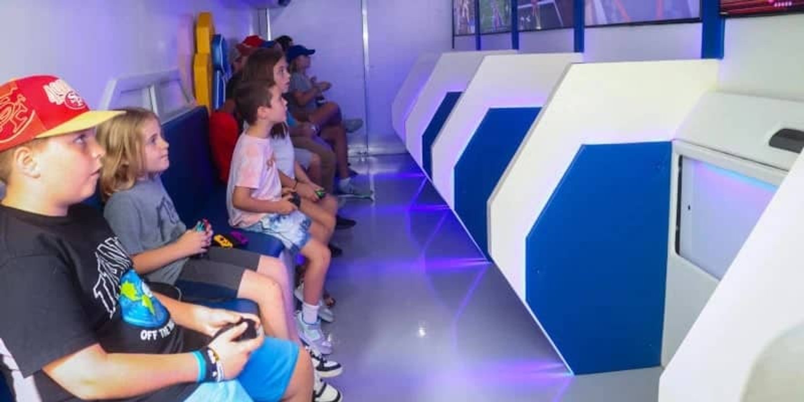 Interior of the AFK Mobile Arcade gaming trailer with lit screens